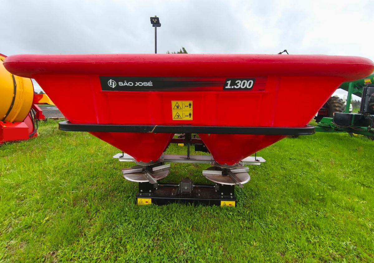 Distribuidor de fertilizante São José 1.300, rojo, con platos de acero inoxidable, en el patio de Agromalleco en Victoria
